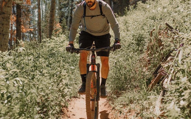 man riding a bike on a trail in the woods